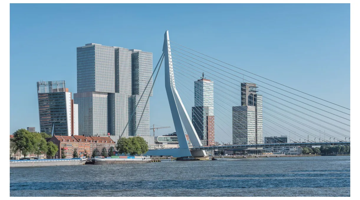 Foto van de Kop van Zuid met de Erasmusbrug en hoge kantoortorens aan de Maas.