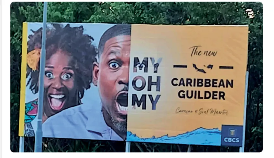 Billboard met twee verbaasd kijkende mensen en de tekst MY OH MY, The new Caribbean Guilder, een handgeschreven regel met Curaçao en Sint Maarten, een silhouet van de eilanden en het logo van de CBCS.