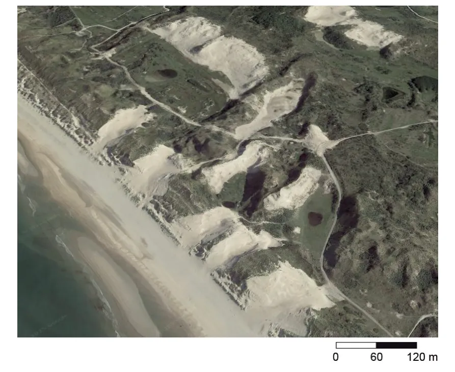 Luchtfoto van de duinen met vijf windsleuven, die als lichte zandvlakten in het duinlandschap zichtbaar zijn, met een schaal van 120 meter.