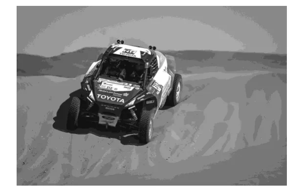 Foto van een rallyauto in de woestijn.