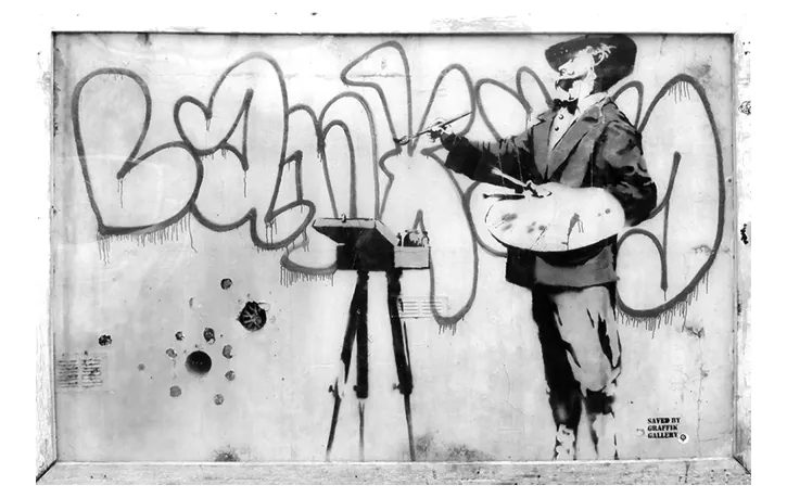 Foto van een graffitikunstwerk in de stijl van Banksy, een schilder met palet en ezel als stencil op een muur.