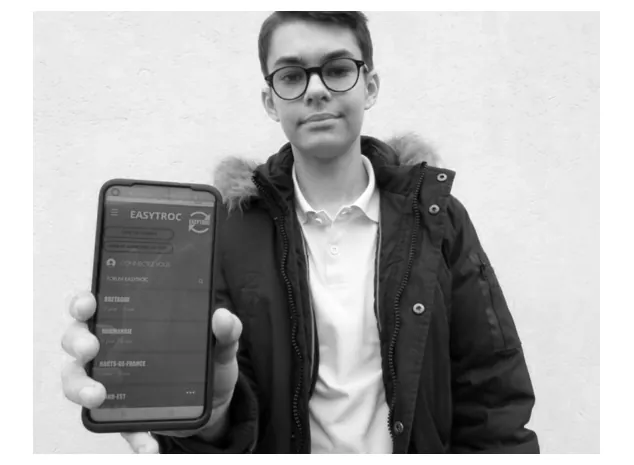 Foto van Lucas Guillou, die een telefoon met de app van Easytroc omhoog houdt.