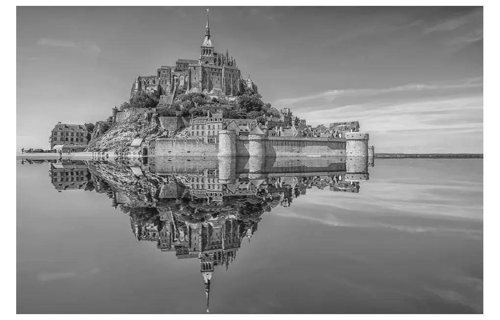 Foto van de Mont-Saint-Michel die weerspiegelt in het water.