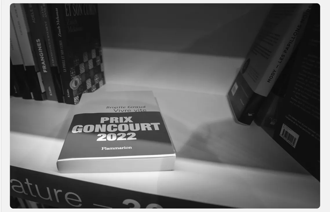Foto van een boek met de tekst Prix Goncourt 2022 op een plank tussen andere boeken.
