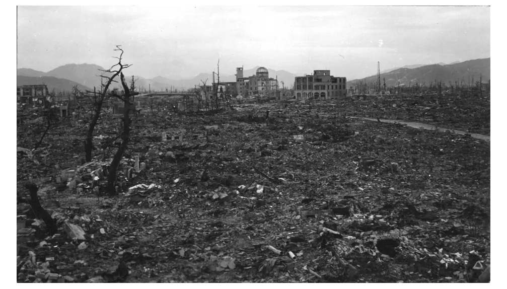 Foto van het verwoeste Hiroshima met kale boomstammen.