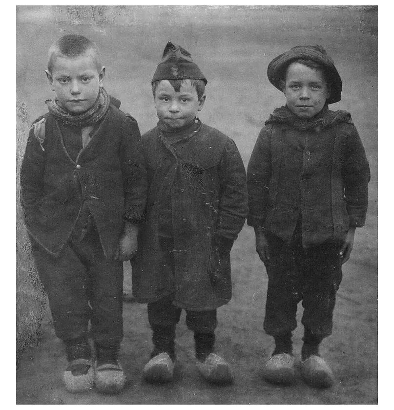 Foto van drie Belgische jongetjes op klompen.