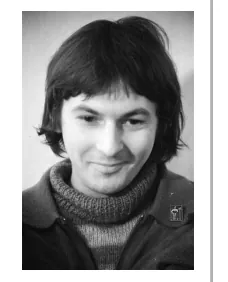 Portretfoto van zanger Mike Naoemenko, een glimlachende man met donker haar en een gebreide trui.