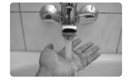 Foto van een kraan waaronder een hand water opvangt.