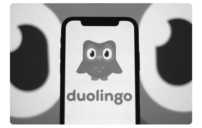 Een telefoon met het Duolingo-logo, de uil Duo op het scherm.