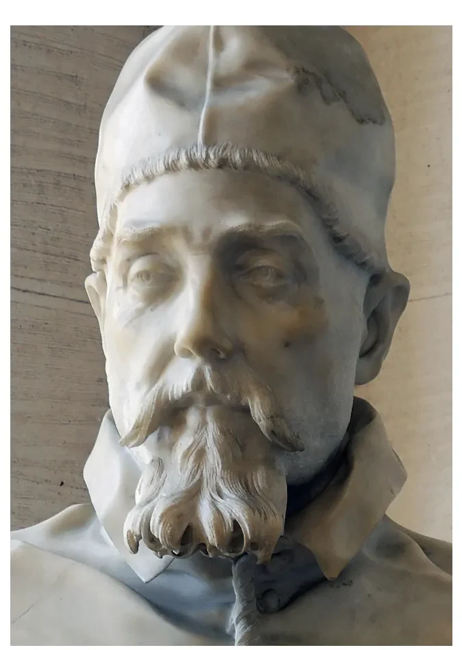 Detail van een marmeren portretbeeld van een oudere man met een golvende baard, een halfgesloten oog en een omgevouwen mantel.