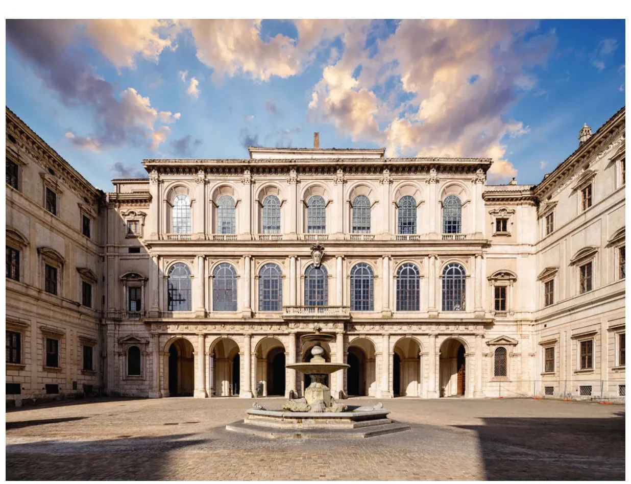 Recente foto van het paleis Barberini in Rome: een langgerekte, lichte gevel met rijen vensters, een binnenplaats met een fontein en bomen.