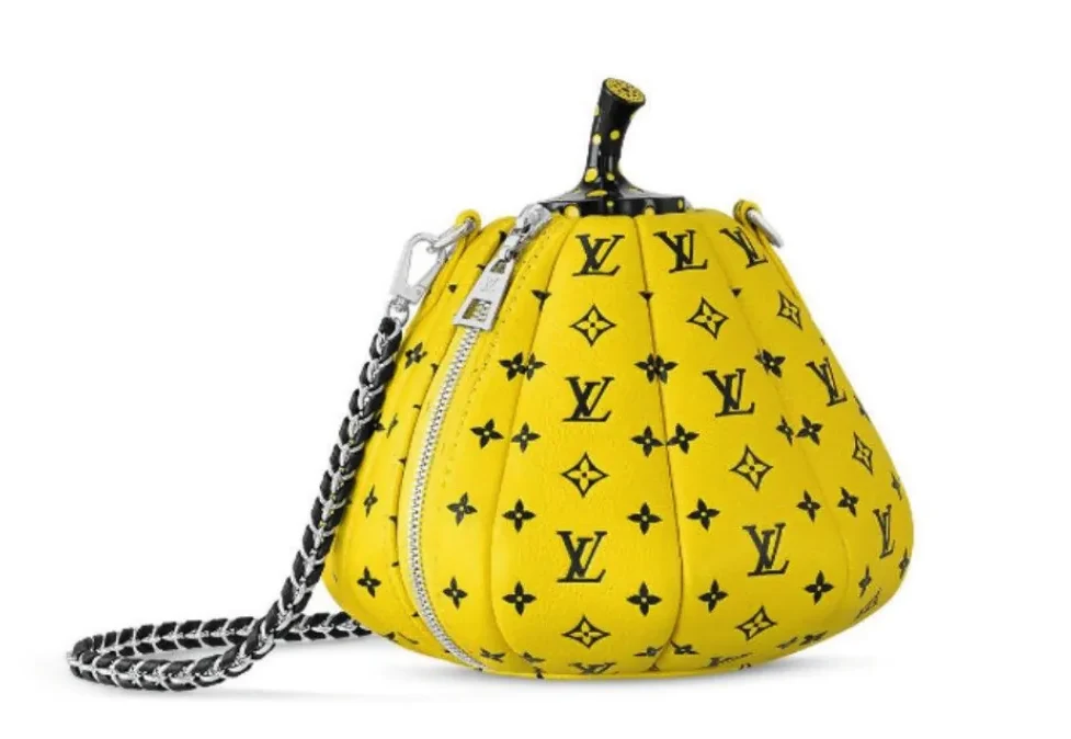 Gele, pompoenvormige handtas met het LV-monogram en een zwart-witte ketting als handvat, op een witte achtergrond.